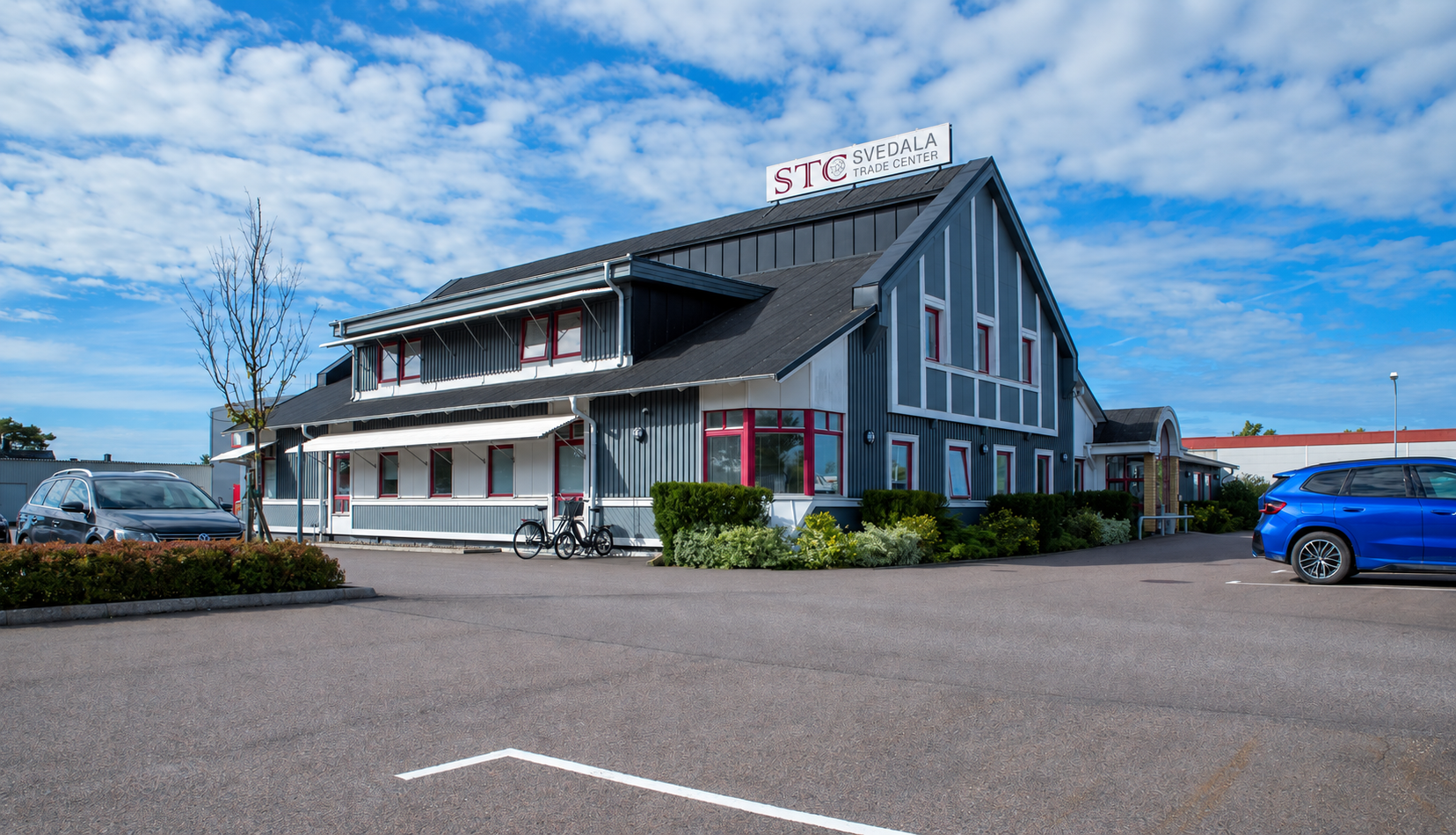 Svedala Trade Centers byggnad med parkering och skylt i dagsljus